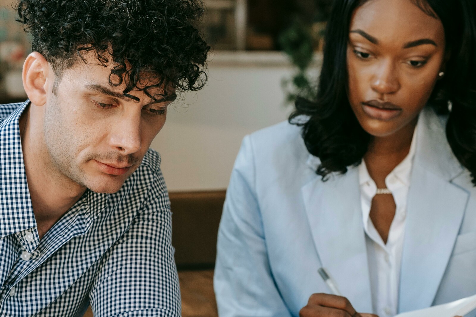 Двое коллег проверяют рабочие заметки рядом с ноутбуком